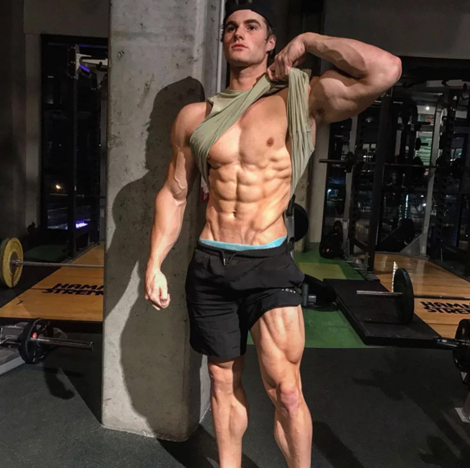 Man posing with black drawstring shorts in the gym