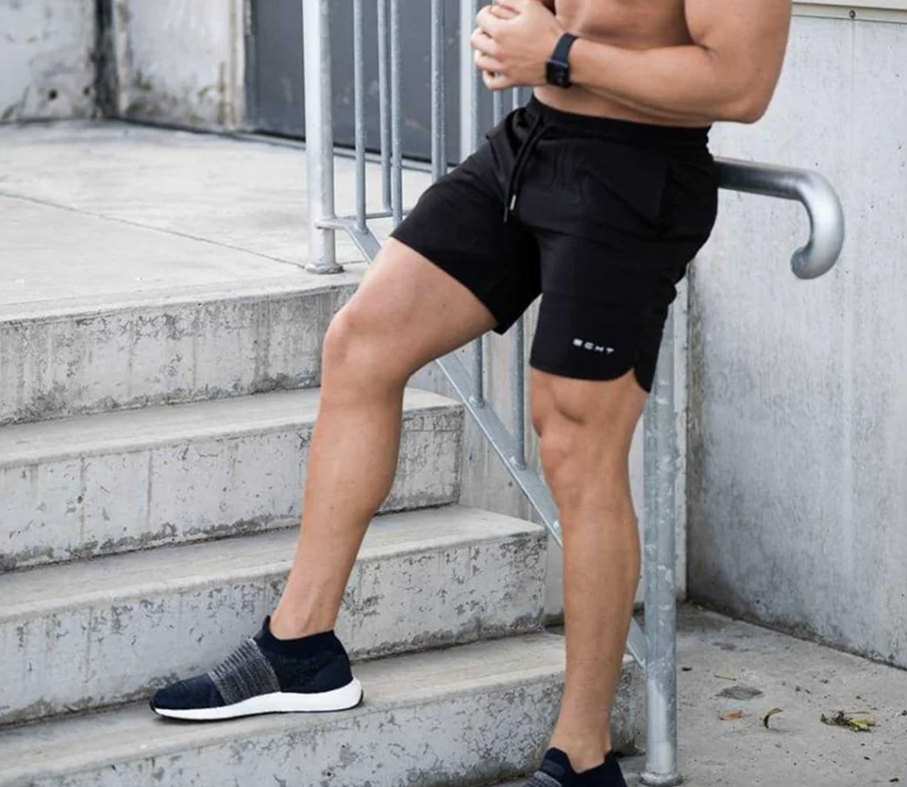 Man outside on a staircase wearing black shorts with drawstring and pockets