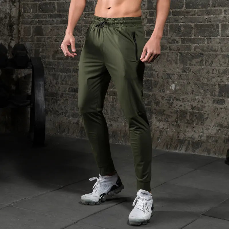 Man in the gym wearing olive green breathable pants for the gym and cardio